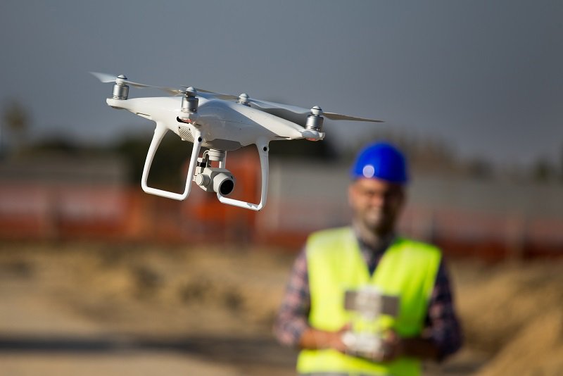 Construction worker with drone at building site